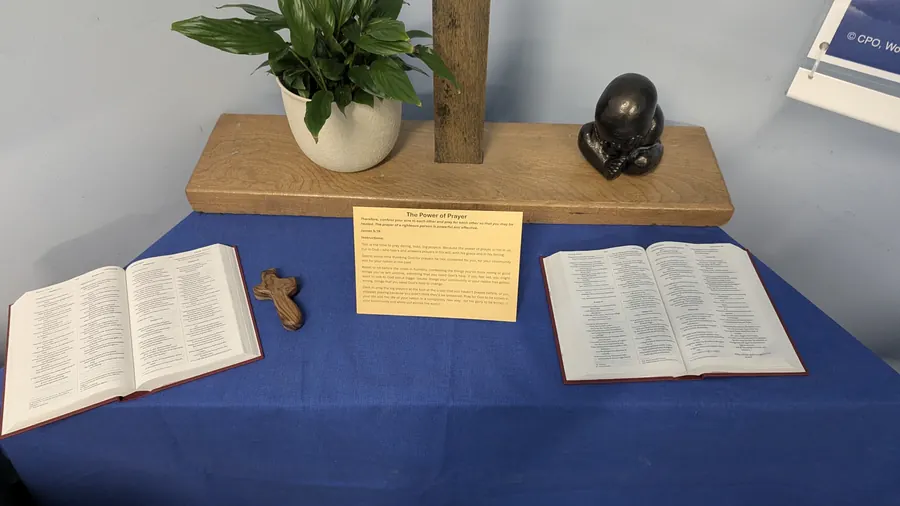 Two open Bibles, a small holding cross and a card titled The Power of Prayer
