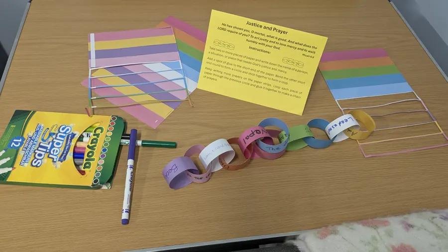 The real paper prayer chain in pastel colours next to a box of felt tips